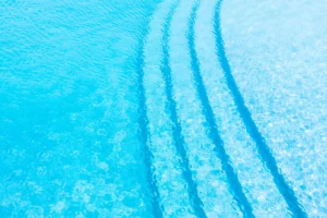Água da piscina cristalina com reflexo do céu azul