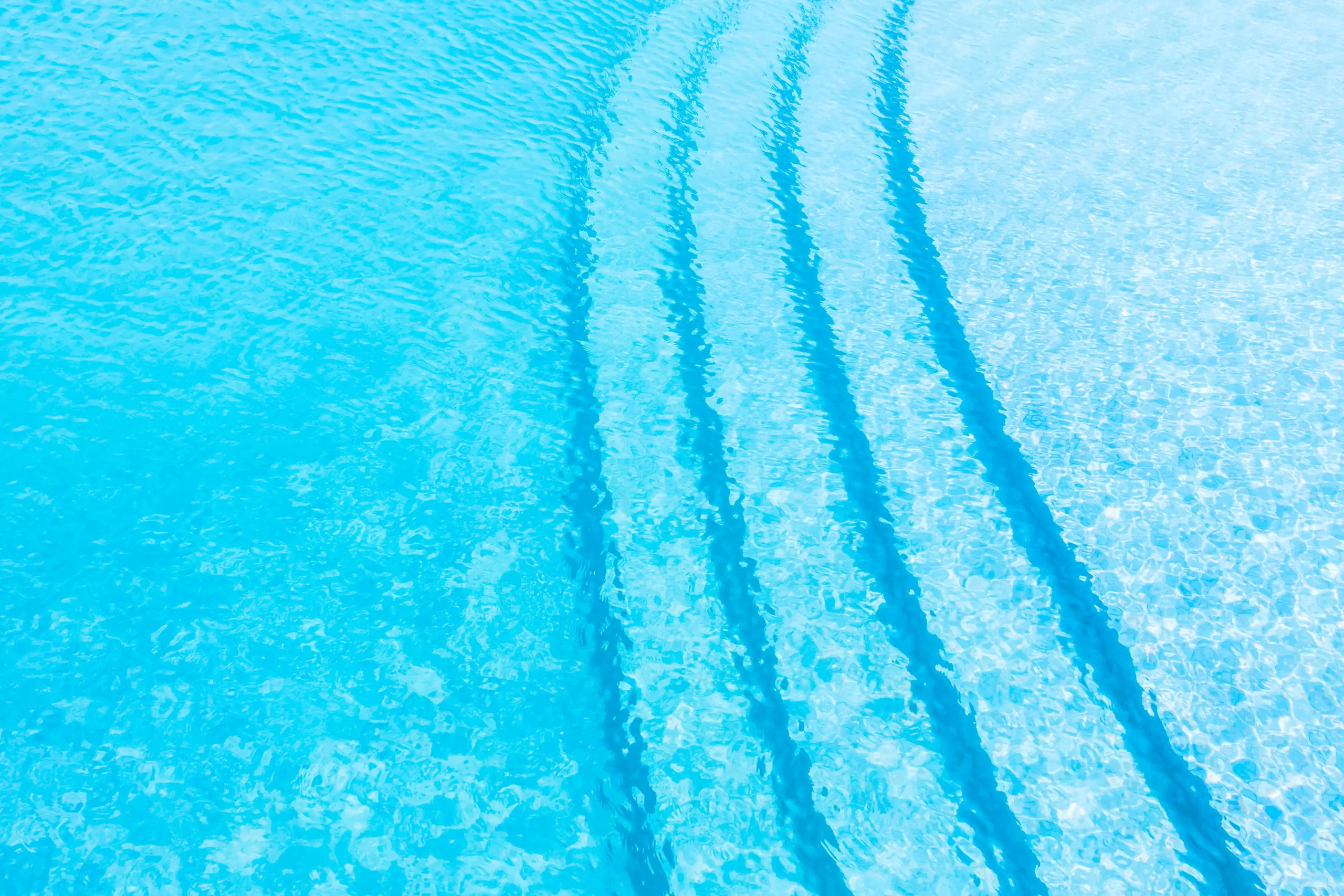 Água da piscina cristalina com reflexo do céu azul